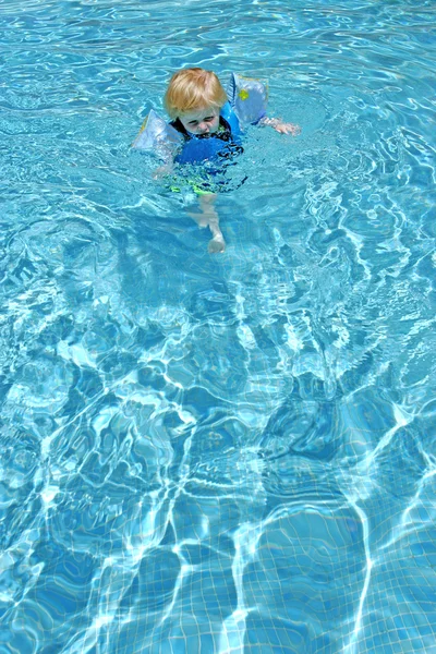 プールで泳ぐことを学ぶ若い男の子 — ストック写真