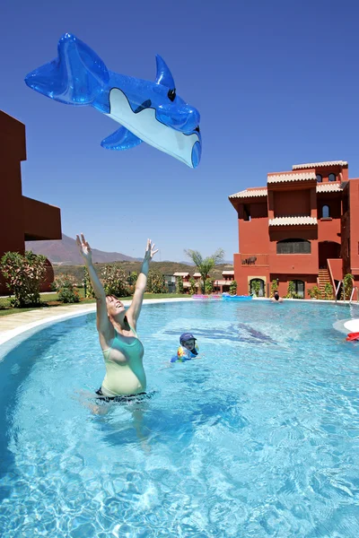 Mulher jogando brinquedo golfinho inflável no ar — Fotografia de Stock