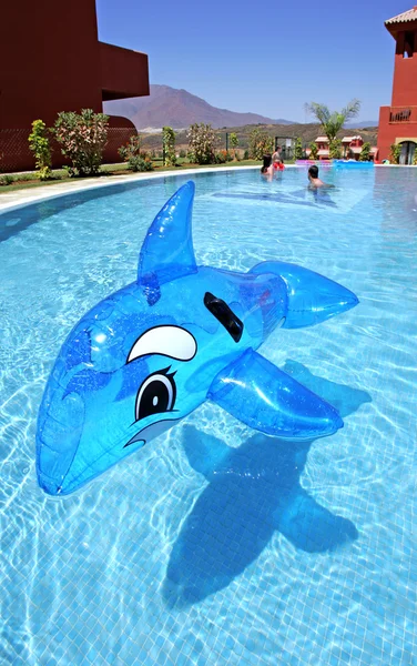 Надувний дельфін на блакитному басейні — стокове фото