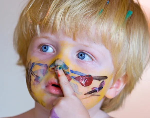 Мальчик, покрытый краской для лица — стоковое фото