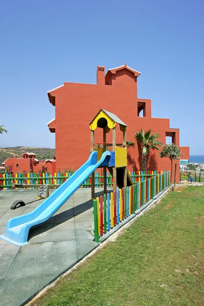 Colourful fence and childrens playground in Spanish vacation apa — Stock Photo, Image