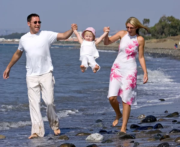 Junge Familie spielt mit Tochter am Strand in Spanien — Stockfoto