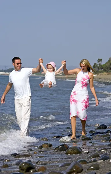 年轻的家庭和女儿一起在西班牙的海滩上玩 — 图库照片