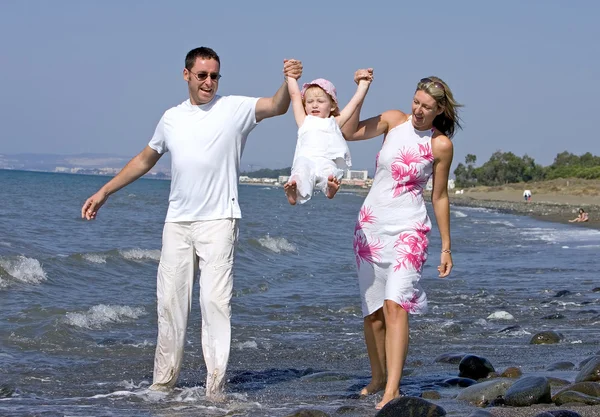 Mladá rodina hrát s dcerou na pláži ve Španělsku — Stock fotografie