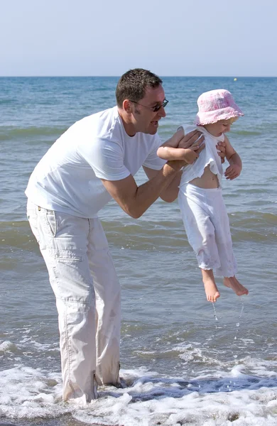 Mann hebt seine Tochter und spielt im Meer — Stockfoto