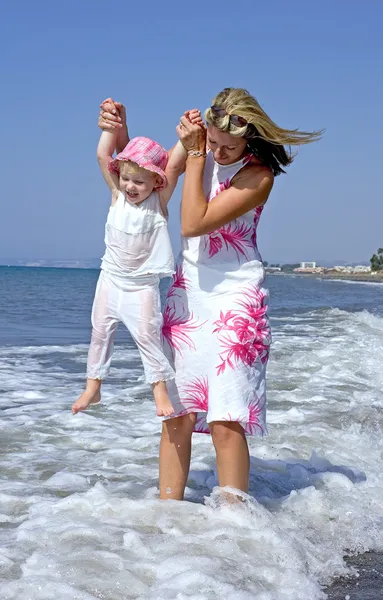 Joven madre e hija jugando en el mar — Foto de Stock