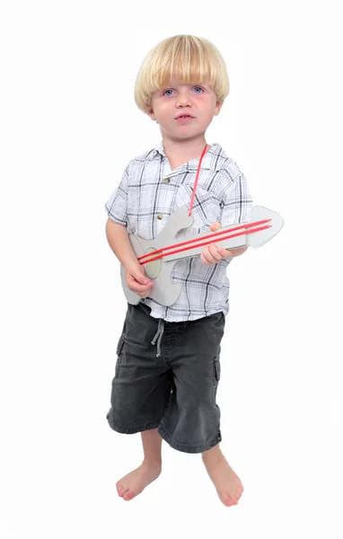 Kleiner Junge spielt Pappgitarre mit weißem Hintergrund — Stockfoto