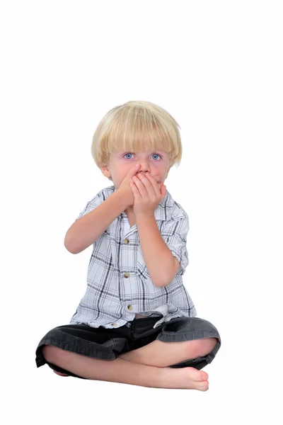 Young boy with his hands over his mouth and white background — Stock Photo, Image