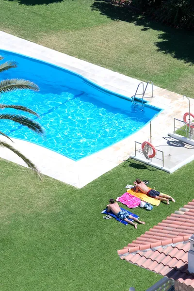 Aerial view of sunbathing by a swimming pool — Stock Photo, Image
