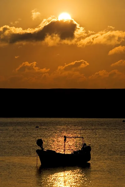 Barco de pesca atracado no mar durante o pôr do sol — Fotografia de Stock