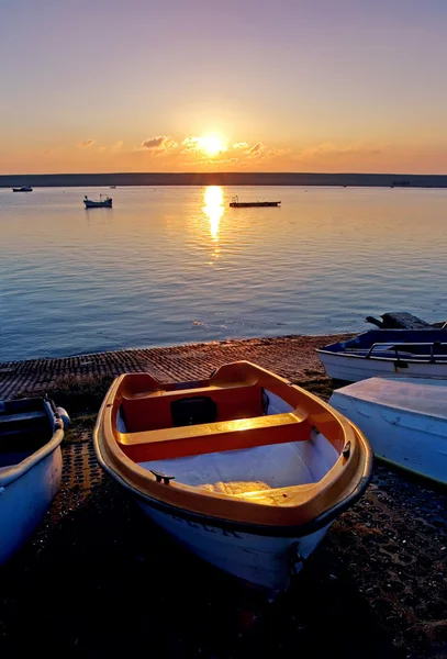 Velhos barcos de remo por mar durante o pôr do sol — Fotografia de Stock