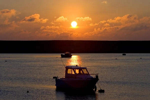 Fishing boats moored at sea during sunset — Stock Photo, Image