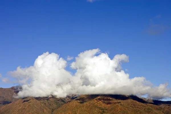 Extrañas y únicas formaciones de nubes sobre una gran montaña —  Fotos de Stock