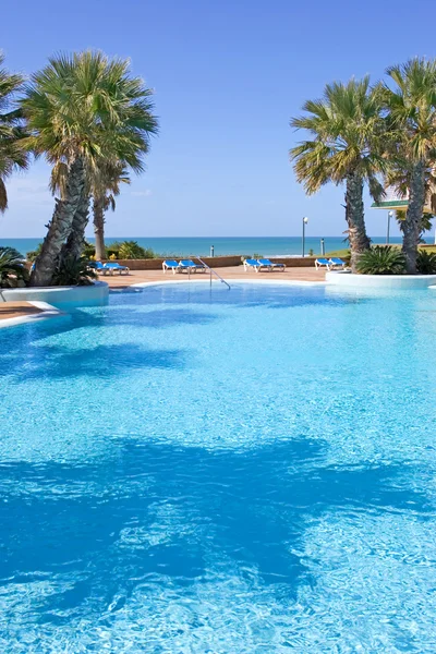 Piscine en hôtel espagnol avec vue sur la mer et palmiers — Photo