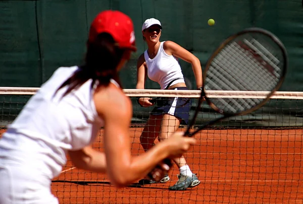 Two young sporty female tennis players having a game in the sun. Stock Photo