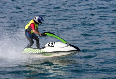 Young man speeding along on jetbike during a race clipart