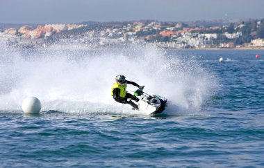 Young man speeding along on jetbike during a race clipart