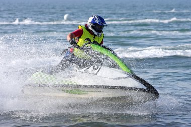 Young man speeding along on jetbike during a race clipart