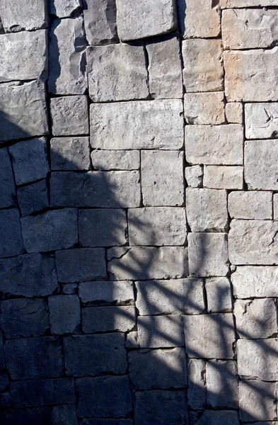 Ombre profonde su un muro di pietra piastrellato — Foto Stock