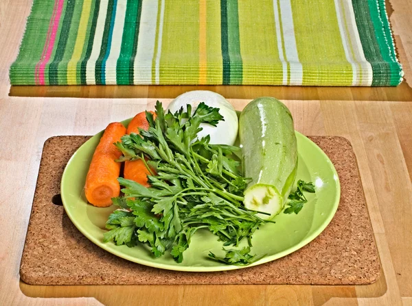 Carote, prezzemolo, cipolla, midollo vegetale su un piatto verde Foto Stock Royalty Free