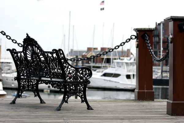 Bench in Boston's harbor at sunset — Stock Photo, Image