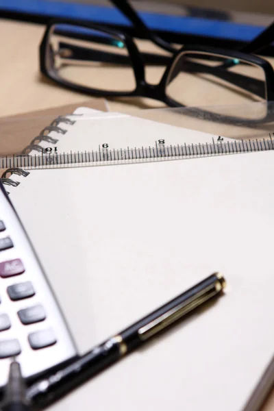 Pero, kniha, pravítko, kalkulačka a brýle — Stock fotografie