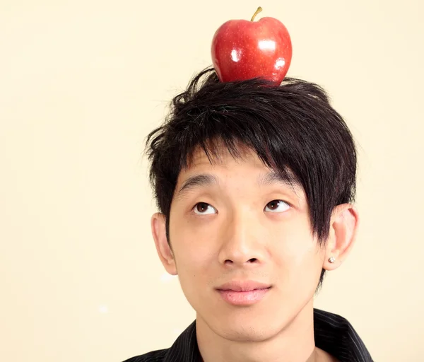 Młody człowiek z jabłkiem na głowie — Zdjęcie stockowe