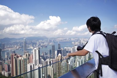 Tourist taking photo of Hong Kong skyline by his digital camera clipart