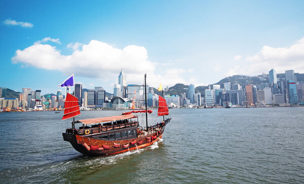 Junk boat with tourists in Hong Kong Victoria Harbour
