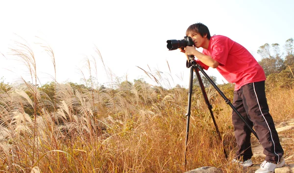 Fotógrafo tomando fotos en el campo — Foto de Stock