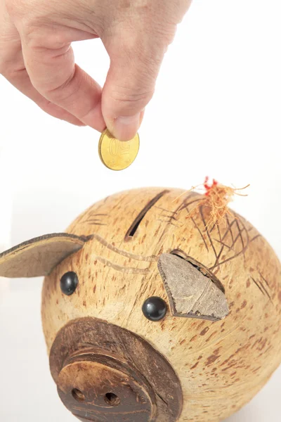 Saving, male hand putting a coin into piggy bank. — Stock Photo, Image