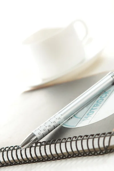 Stift auf weißem Papier mit Tasse Kaffee — Stockfoto
