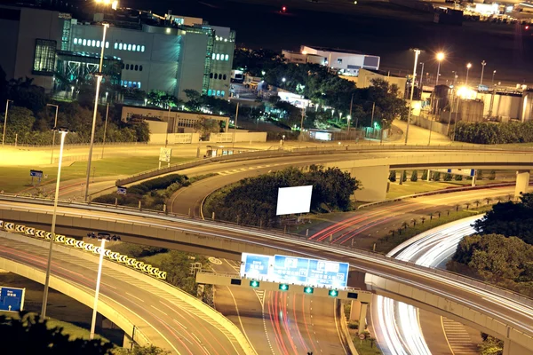 Автострада ночью с легковыми автомобилями в современном городе . — стоковое фото