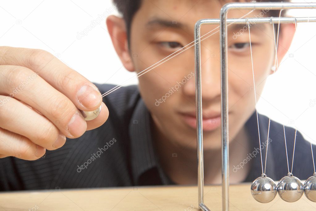 Man moving Newton balls in office Stock Photo by ©cozyta 6402024