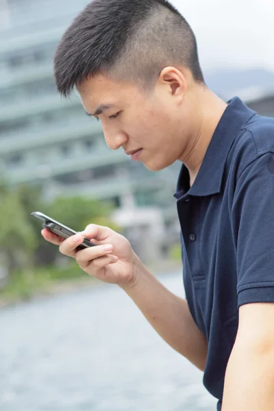 Mann checkt sein Handy im Freien — Stockfoto