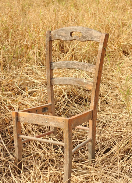 Сломанный стул на желтой траве — стоковое фото