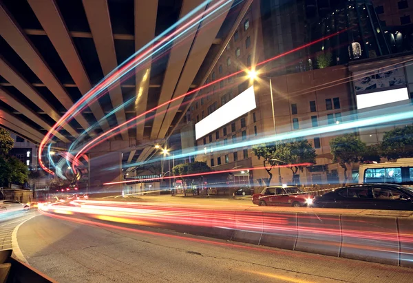 Trilhas de luz de ônibus borradas no centro da cidade noite-paisagem — Fotografia de Stock