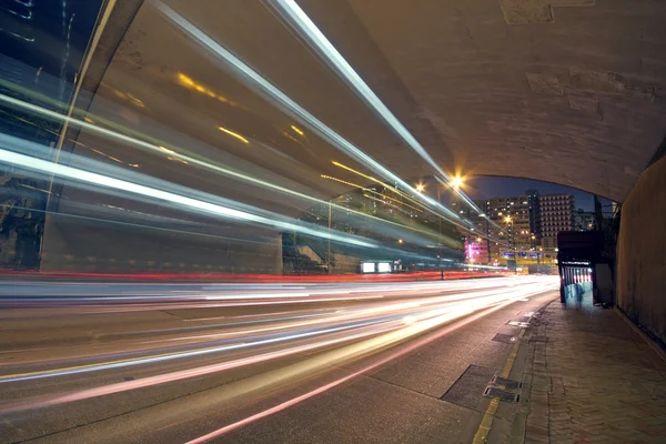 Blurred bus light trails in downtown night-scape — Stock Photo, Image