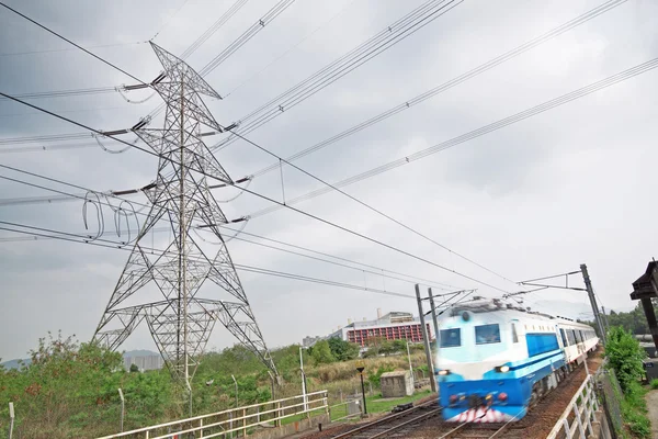 Comboios de passageiros em movimento e torre eléctrica em segundo plano — Fotografia de Stock