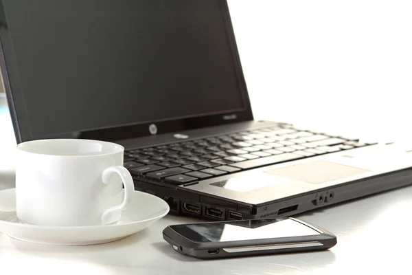 Una taza de café y una pluma en un portátil — Foto de Stock