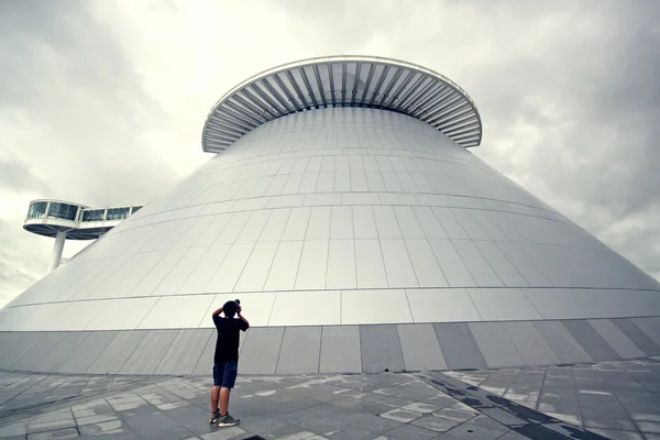 Мужчина фотографирует современное здание — стоковое фото