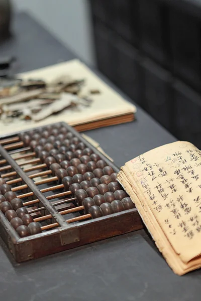 Abacus en boek op de tafel in een chinese oude winkel — Stockfoto