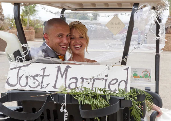 Bruden och brudgummen i en golfbil — Stockfoto