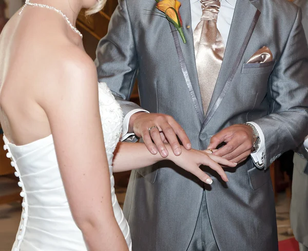 Bruden och brudgummen i kyrkan exchaning ringar — Stockfoto