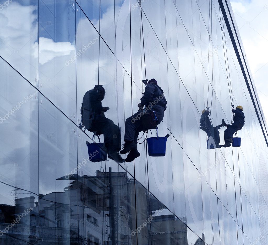 Window washers, hanging on the rope, cleaning
