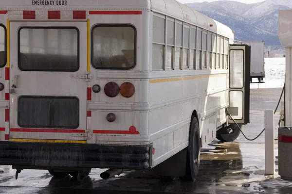Witte schoolbus pompen gas — Stockfoto