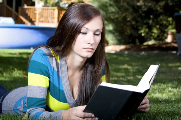 Schönes Mädchen im Park beim Lesen eines Buches — Stockfoto