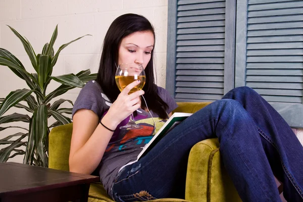 Ragazza carina che beve mentre legge un libro — Foto Stock
