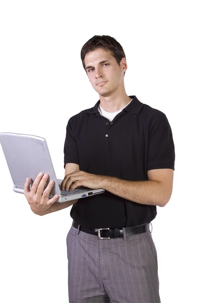 Genç adam dizüstü bilgisayarda ayakta ve çalışıyor. Telifsiz Stok Fotoğraflar