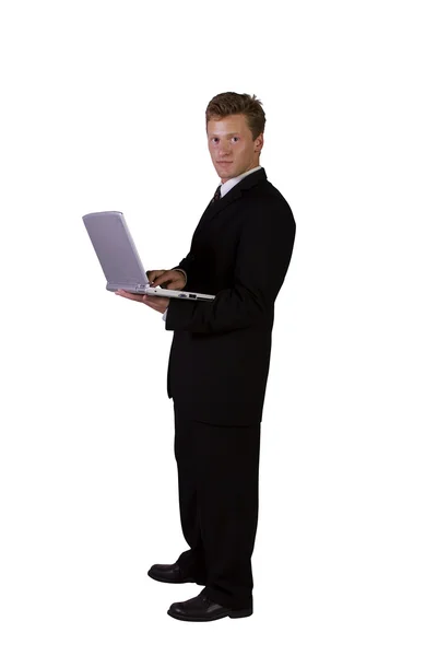 Giovane uomo in piedi e al lavoro sul computer portatile — Foto Stock
